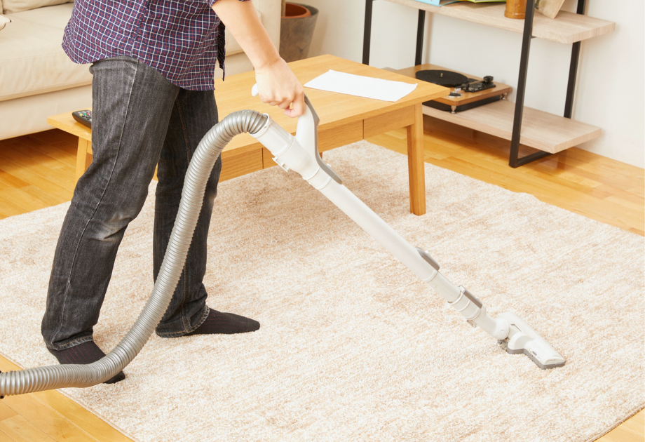 man vacuuming rug
